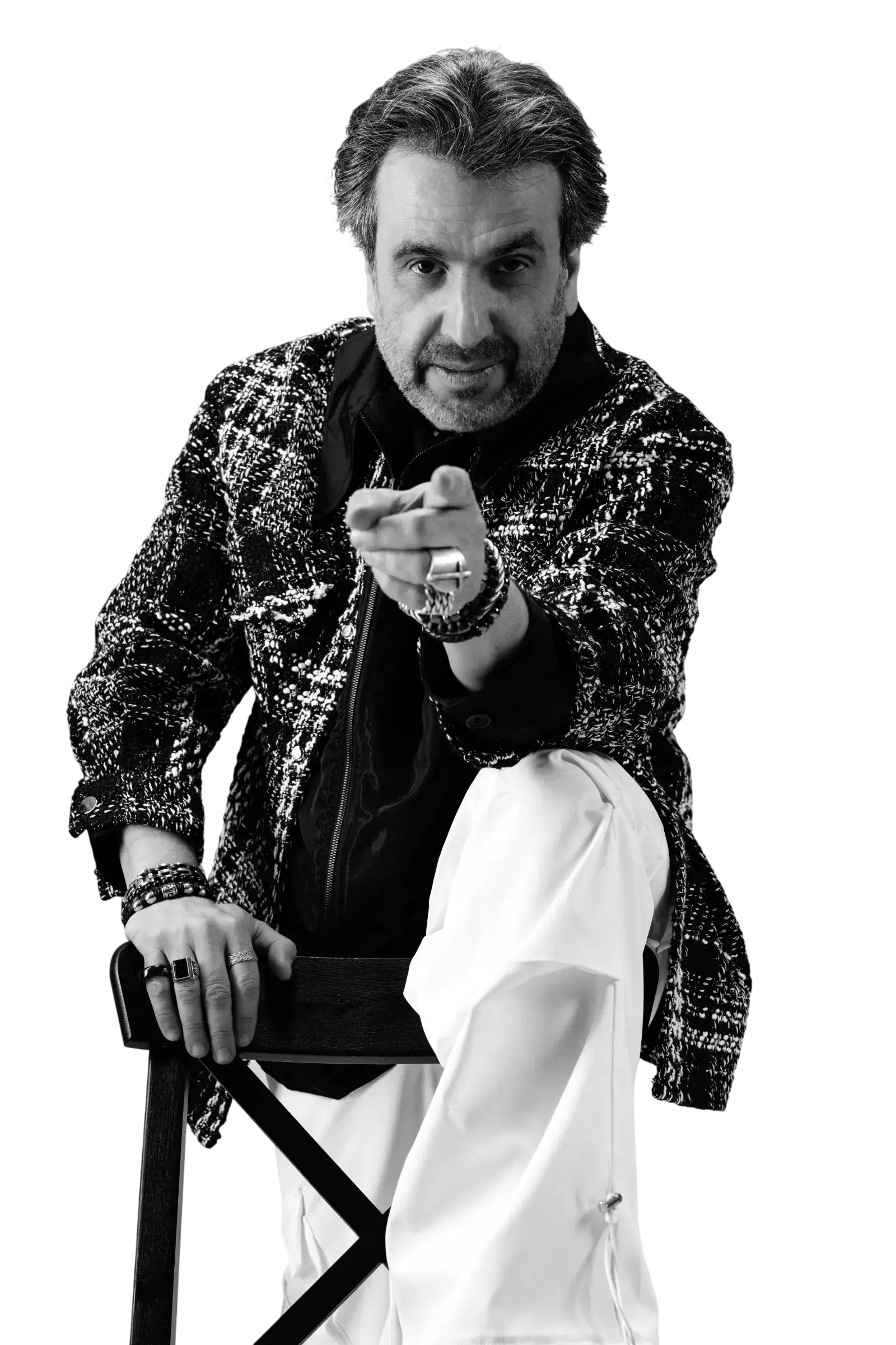 Black and white portrait of Ramez Basmaji seated, pointing towards the camera