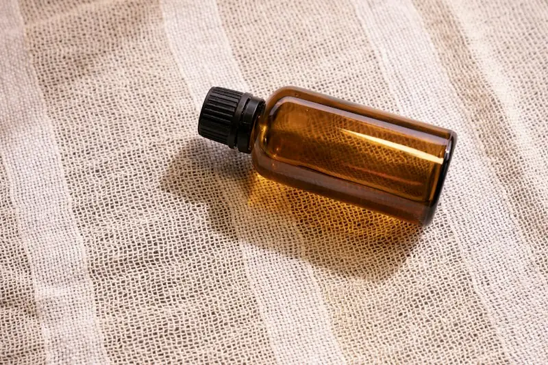 Amber glass dropper bottle lying on striped linen