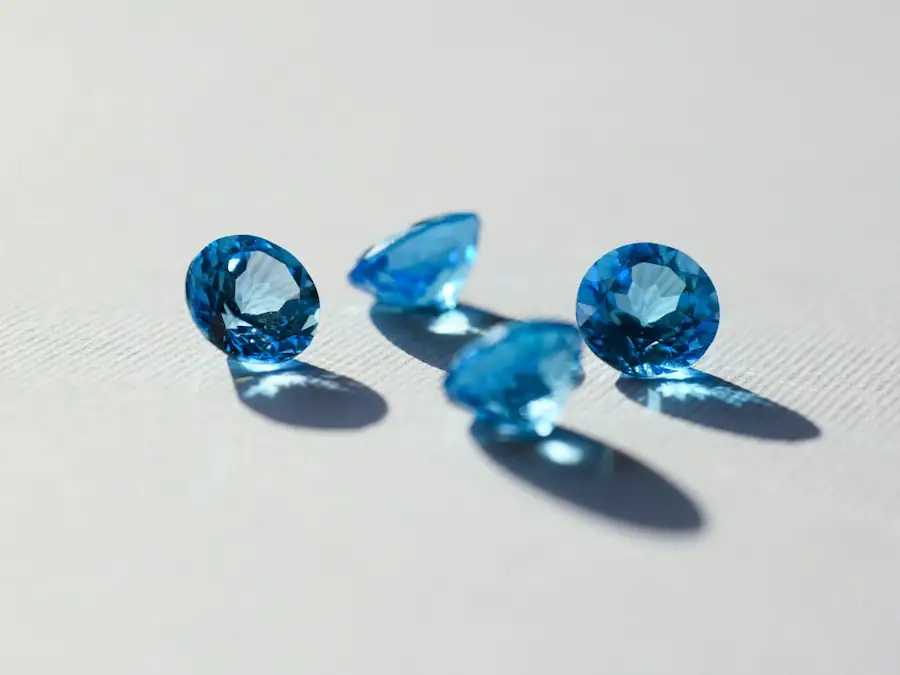 Four faceted blue topaz gemstones on a white surface