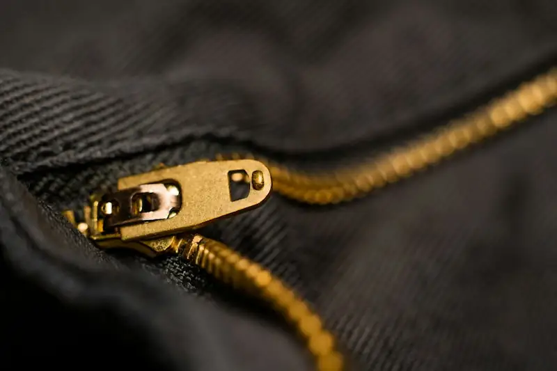 Brass zipper pull on a black fabric