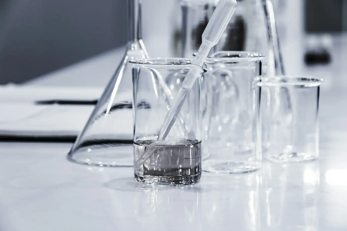 Laboratory glassware with a clear liquid being poured