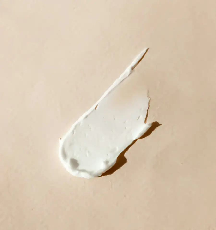 Swatch of white cream on a beige surface