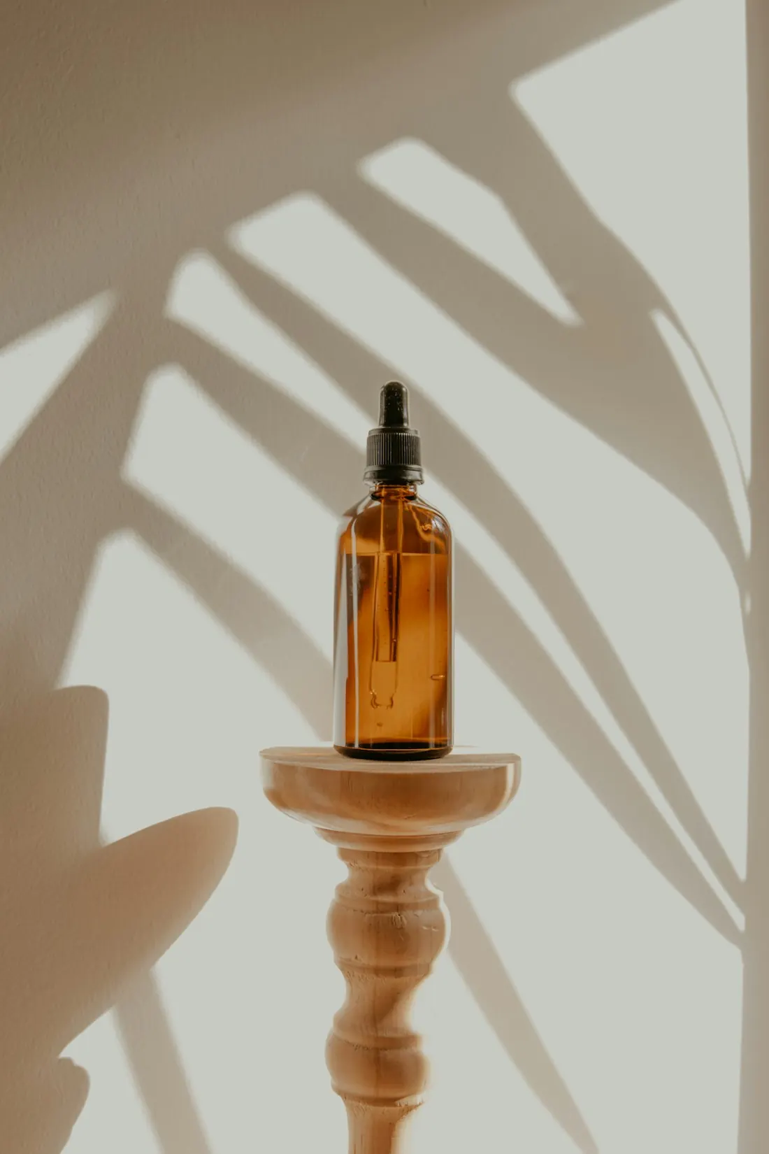 Amber glass dropper bottle on a wooden stand