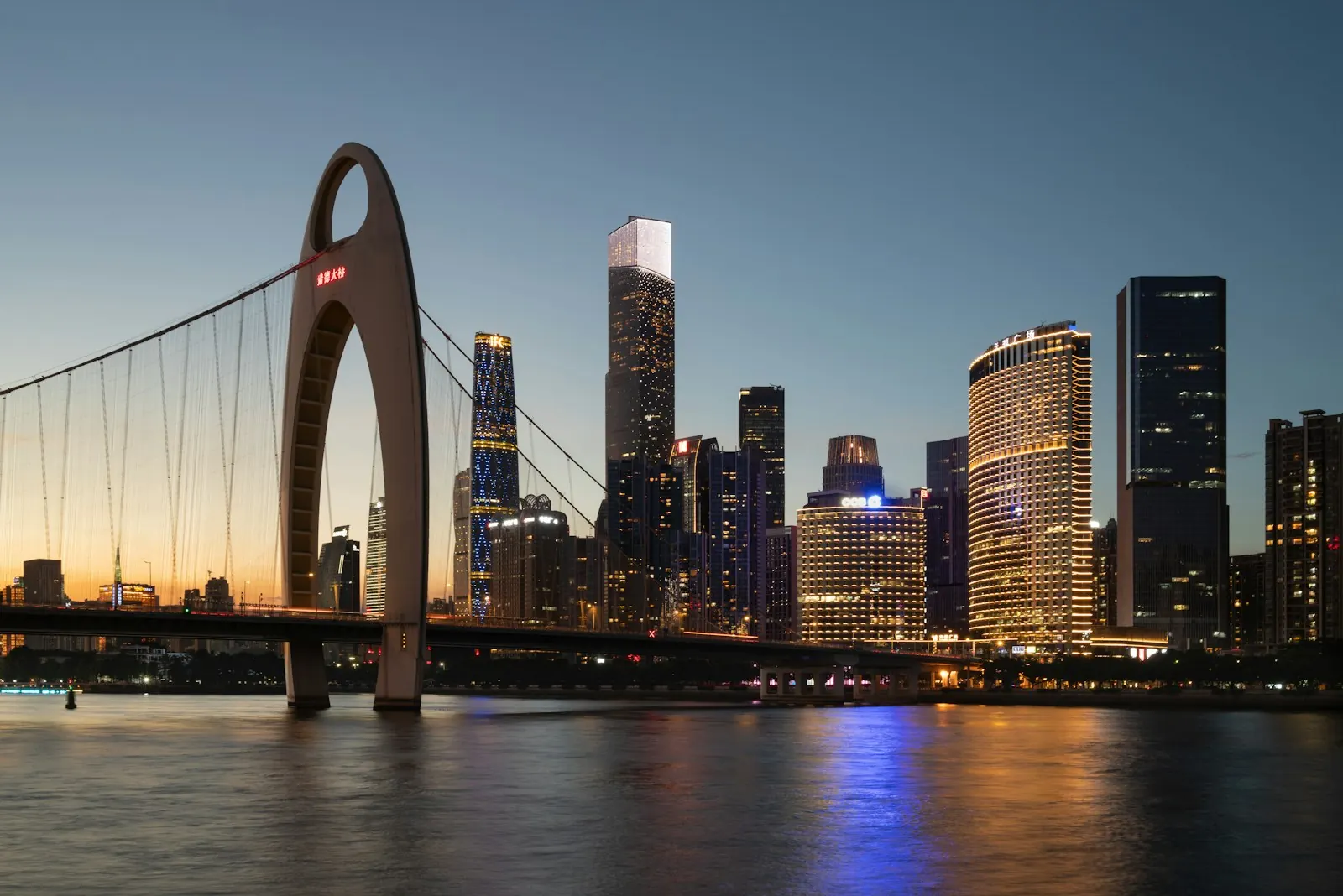 Guangzhou skyline and a river bridge at dusk