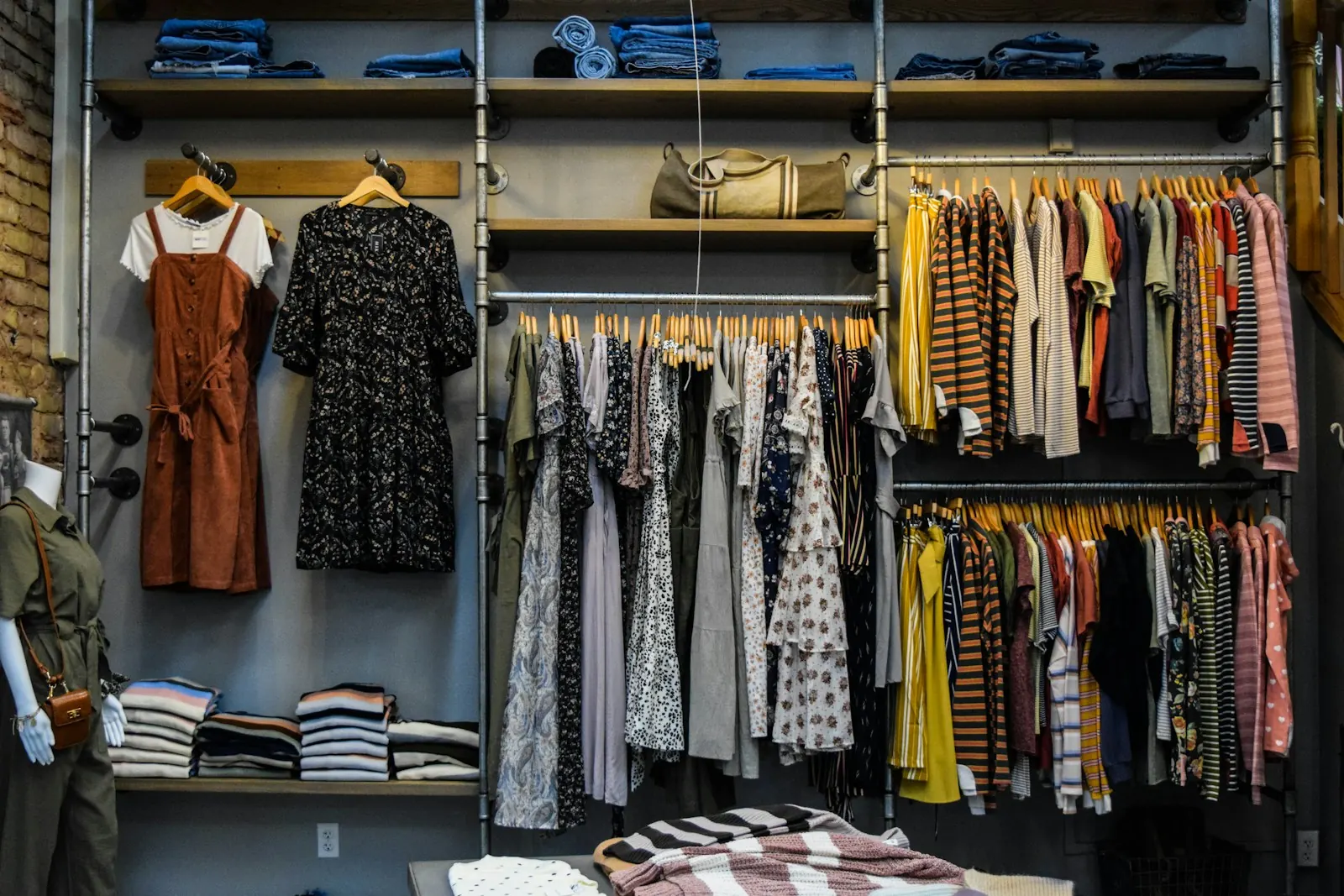 Retail store wall of dresses and folded clothing