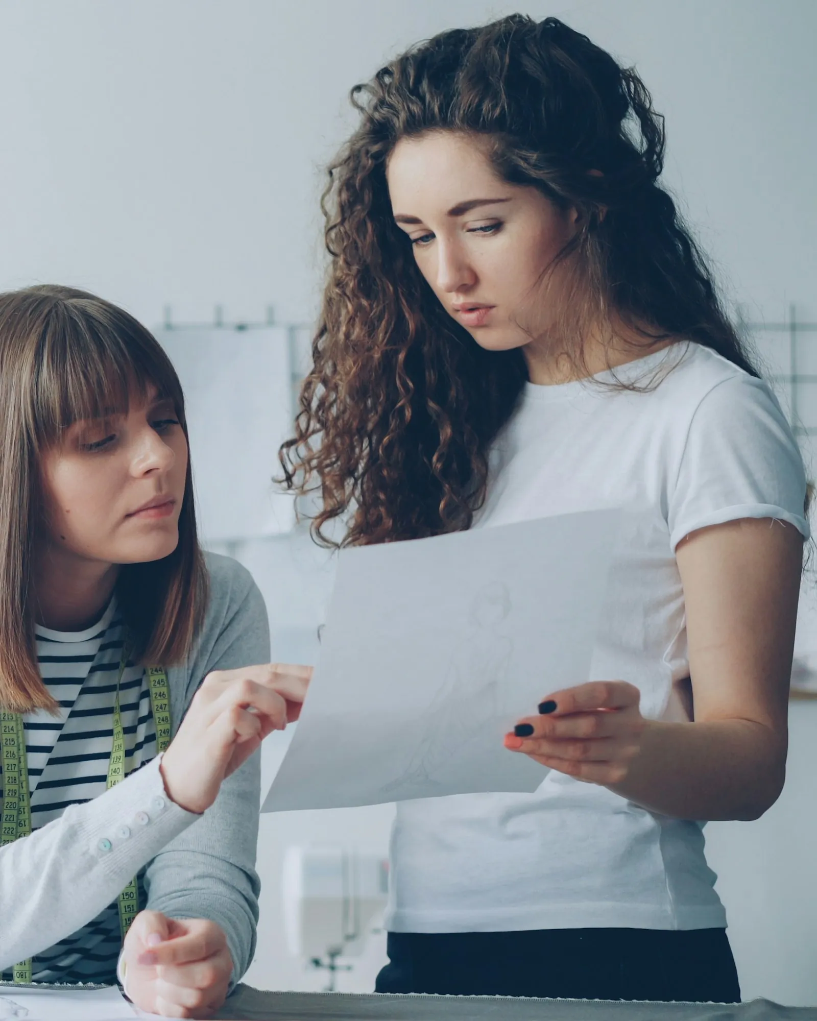 Two fashion designers reviewing a sketch together in their studio