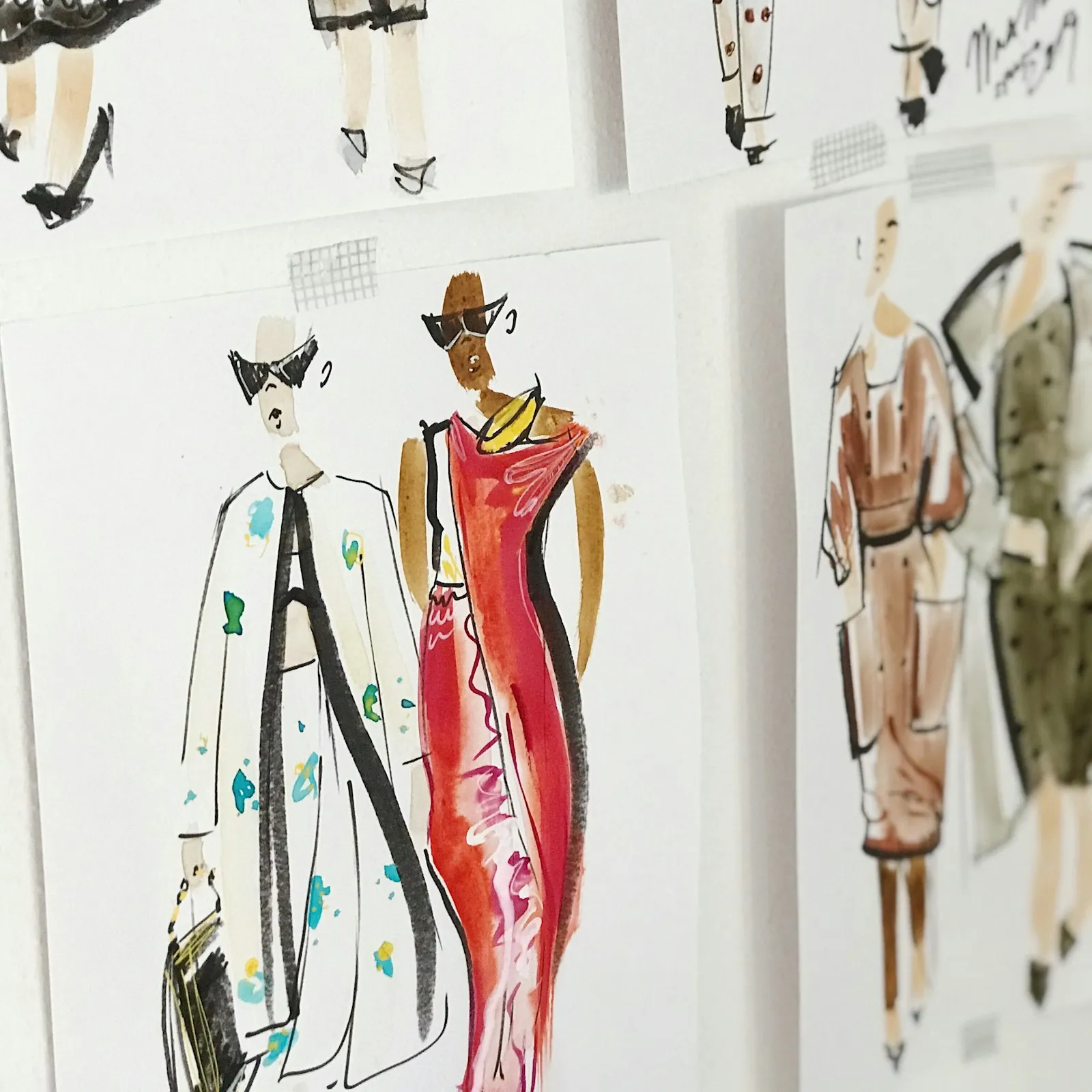 Fashion illustrations pinned to a studio wall