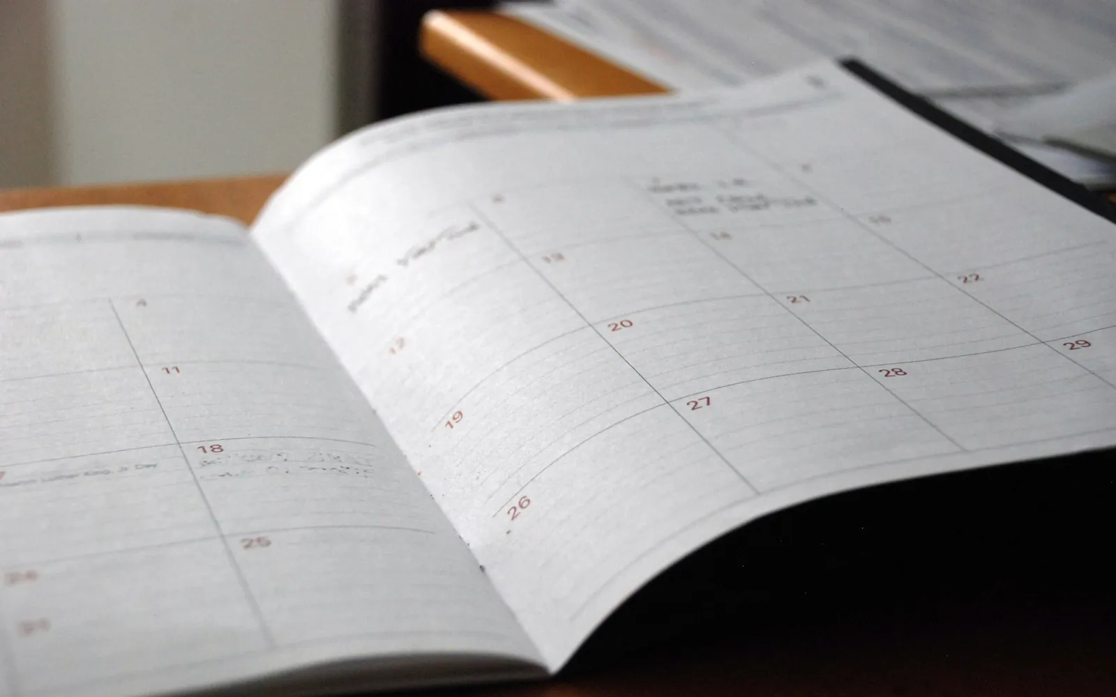 Monthly planner open on a wooden desk
