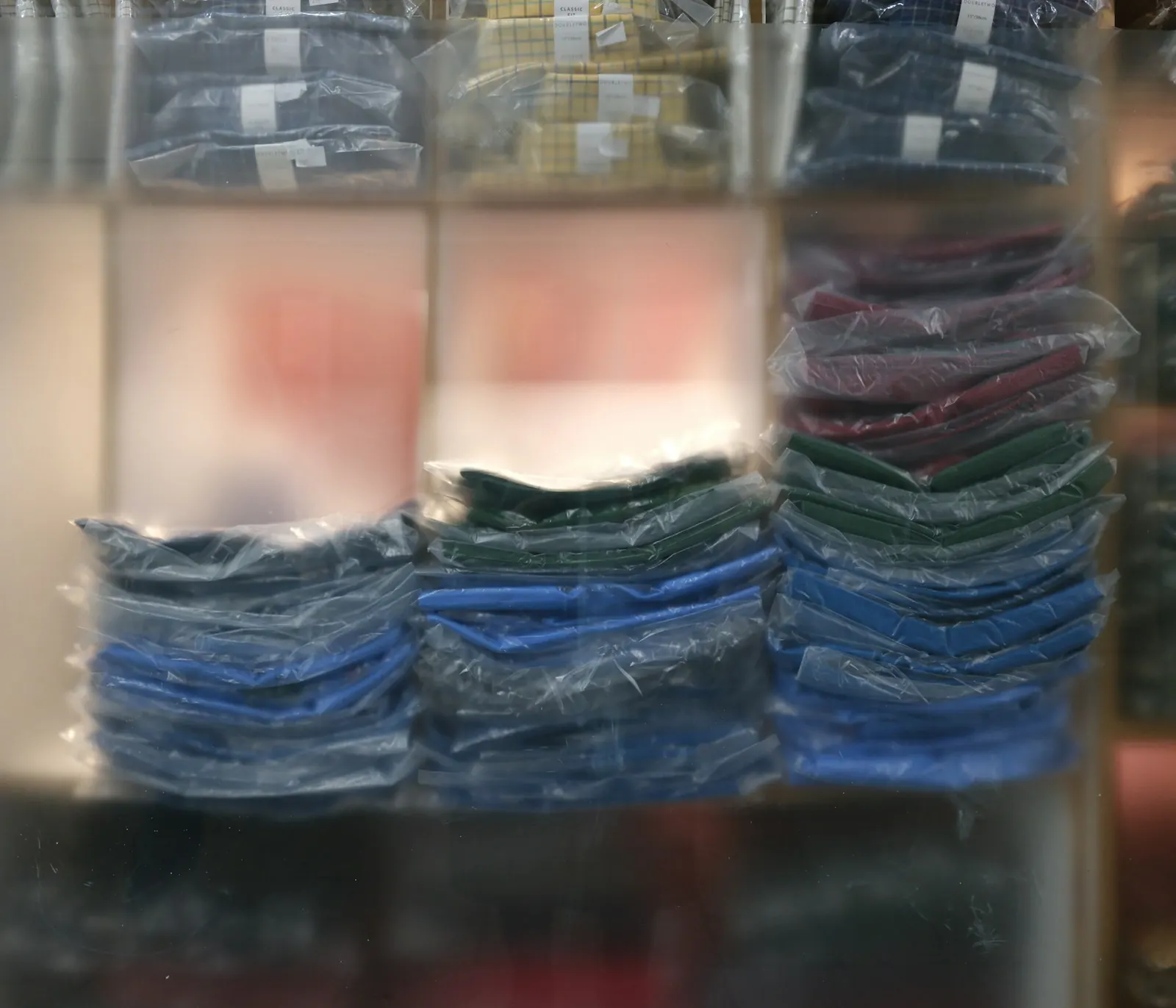 Stacks of folded garments sealed in clear polybags