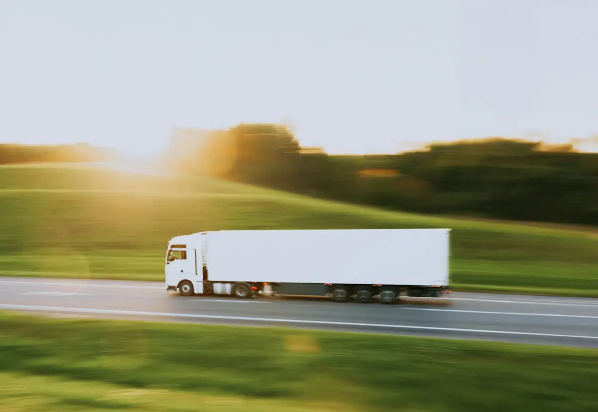 White delivery truck driving along a highway