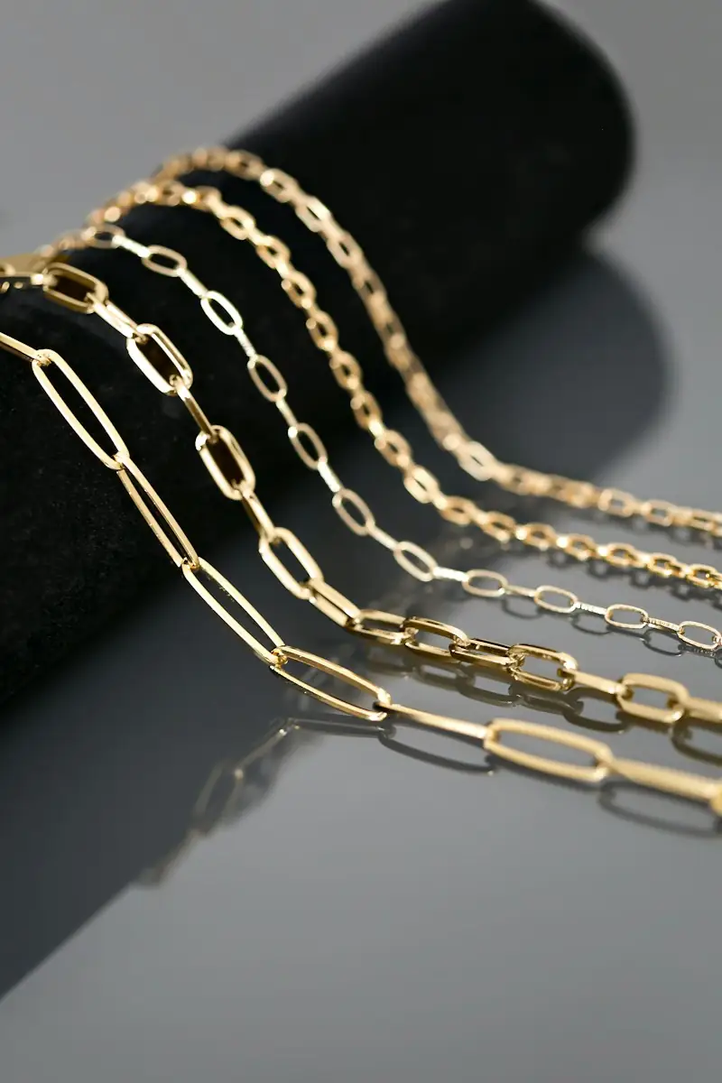 Gold paperclip chains laid on a dark roll