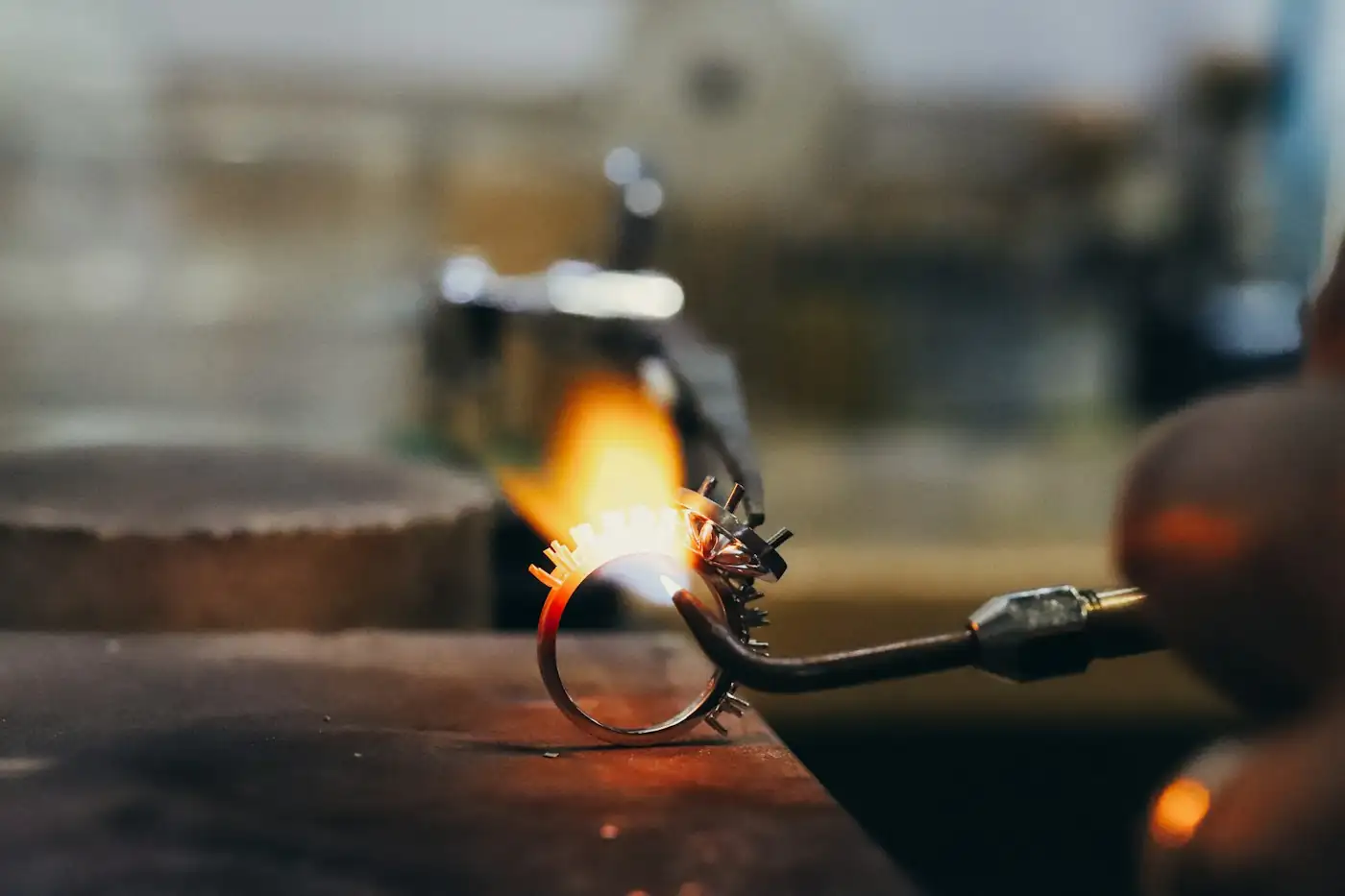 Jeweler heating a ring with a torch flame at the bench