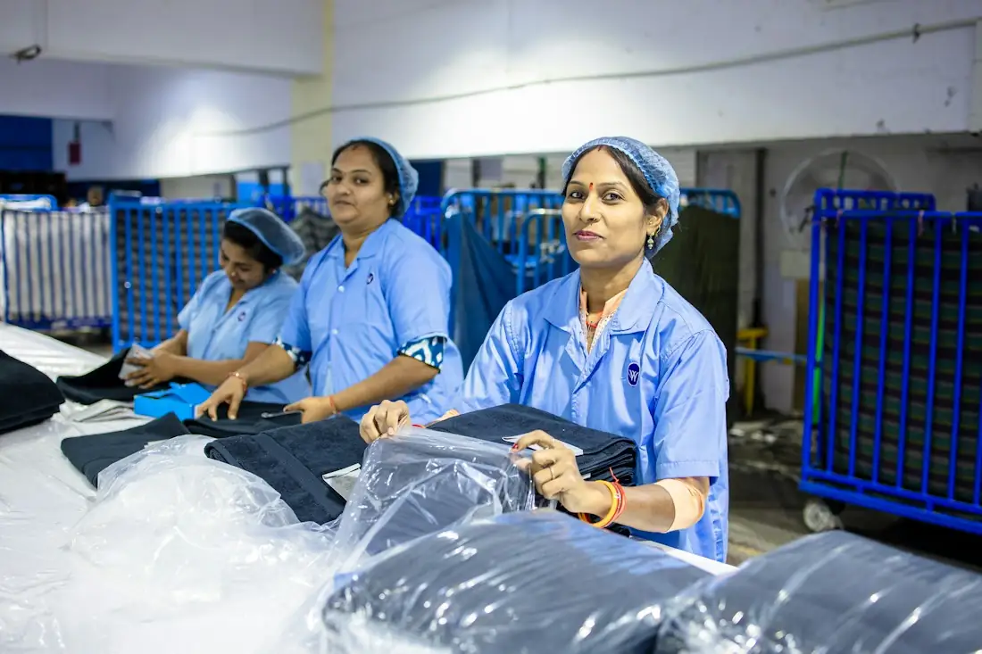 Garment workers folding and bagging finished garments
