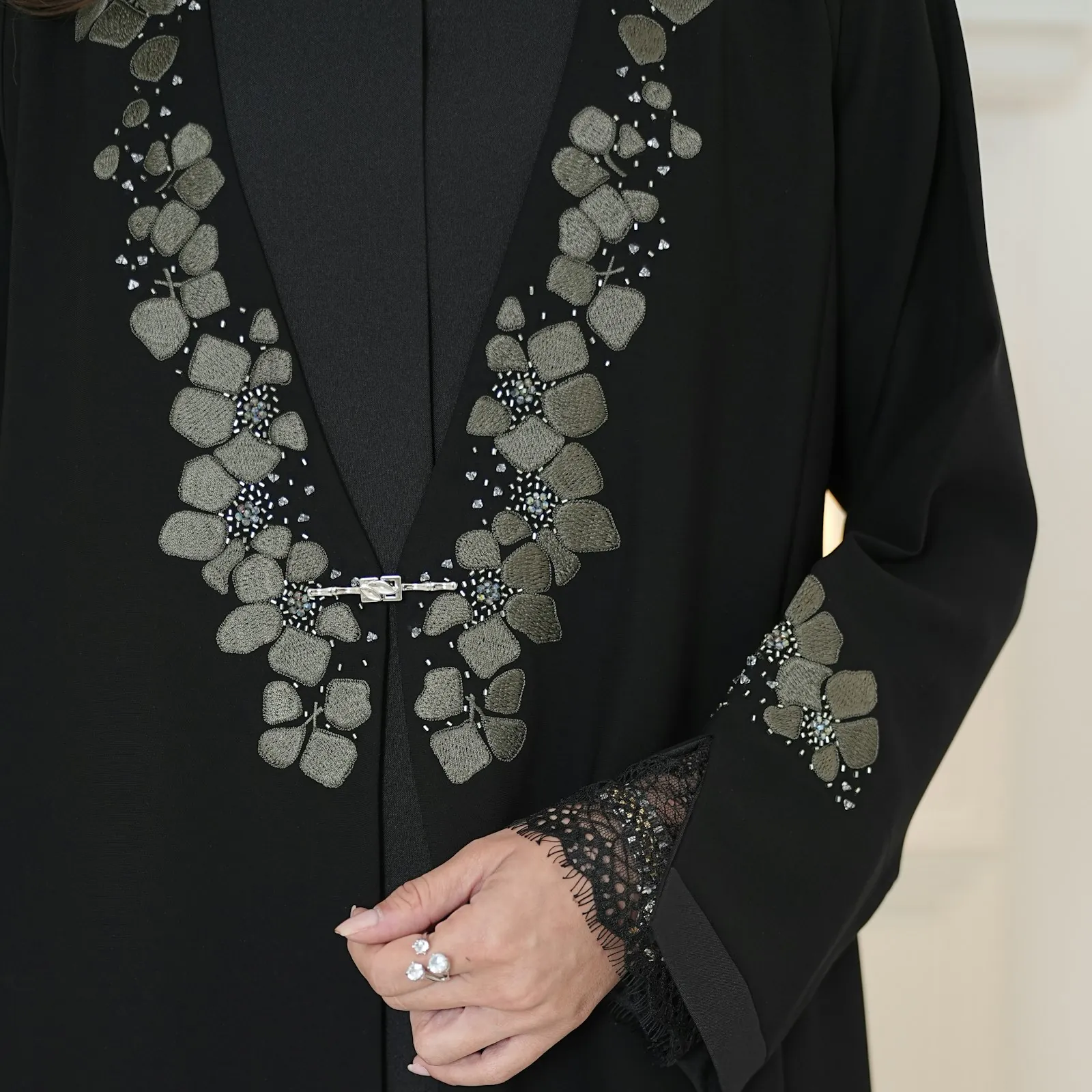 Close-up of a black abaya with embroidered floral detail on the sleeve