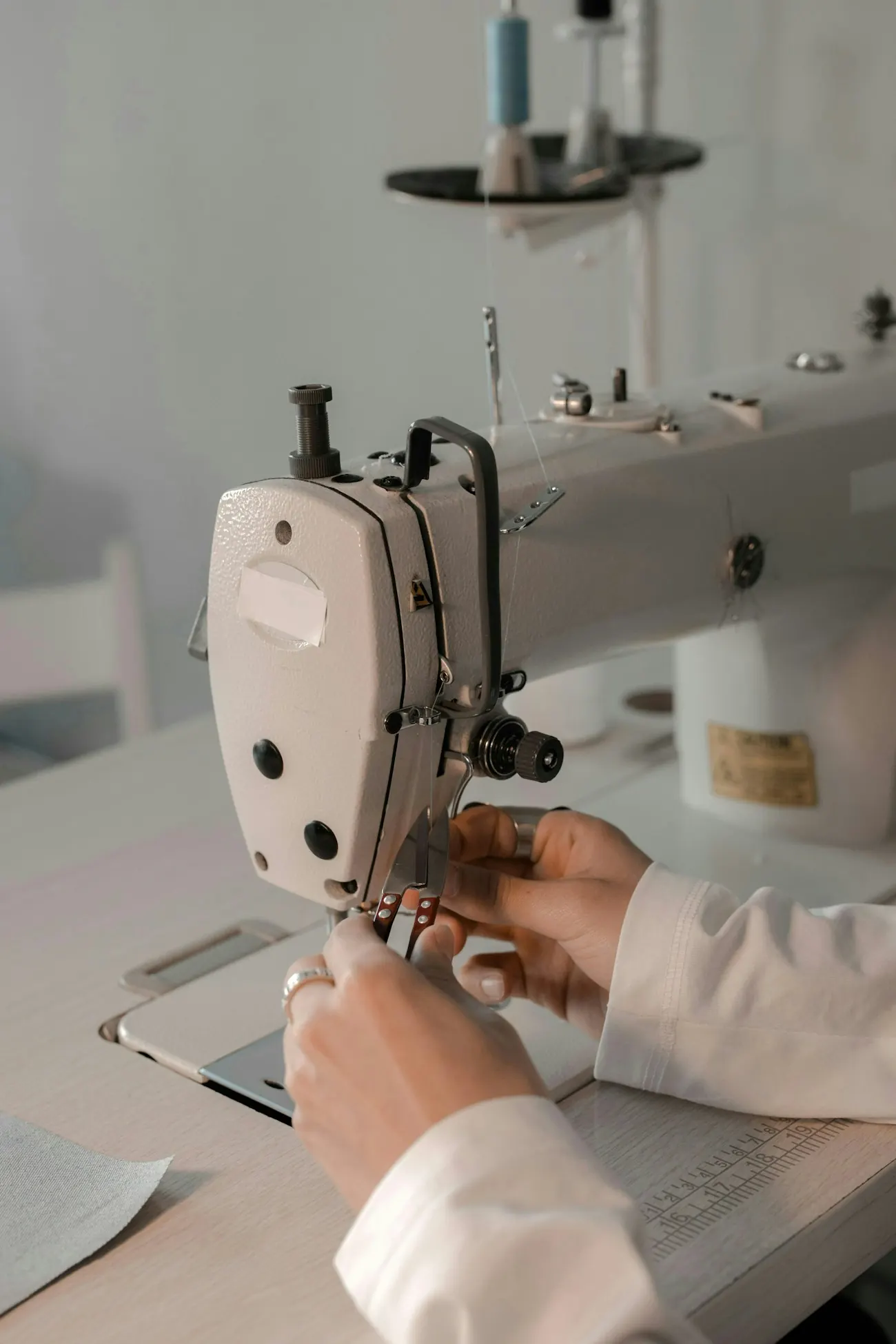 Hands guiding fabric through an industrial sewing machine
