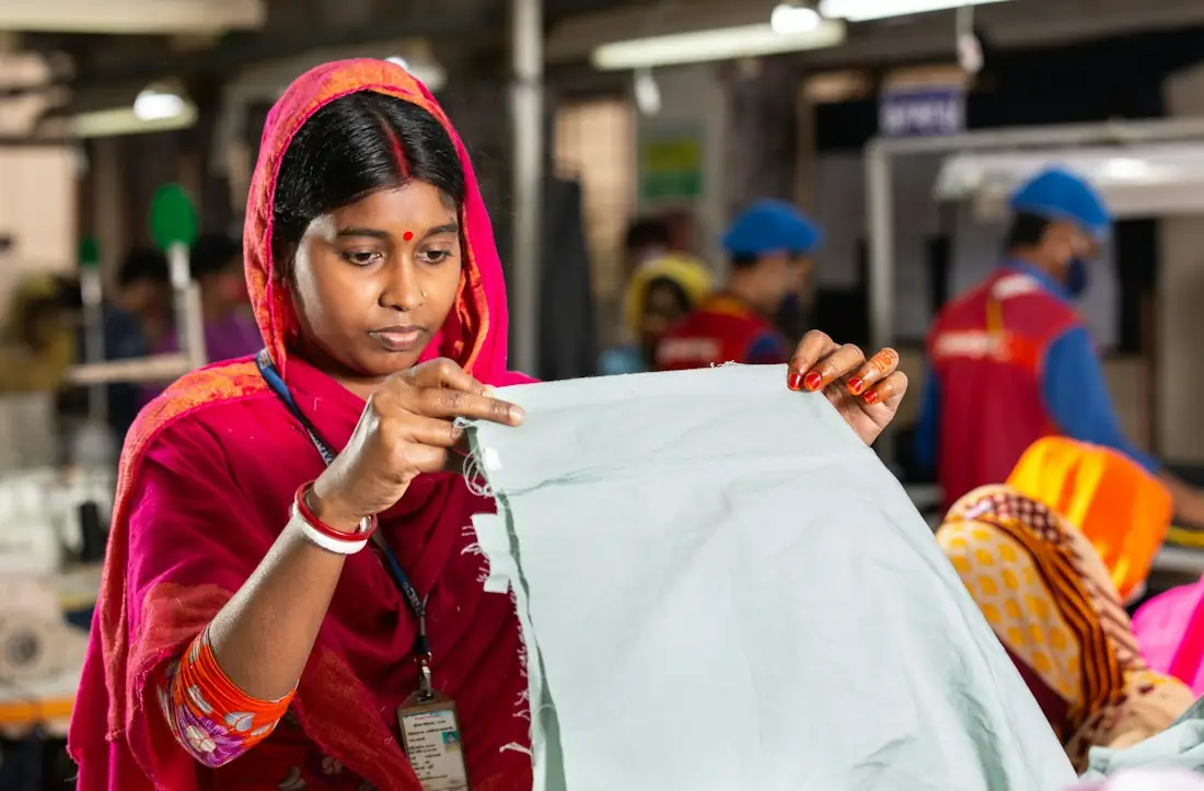 Factory worker checking a length of fabric before cutting