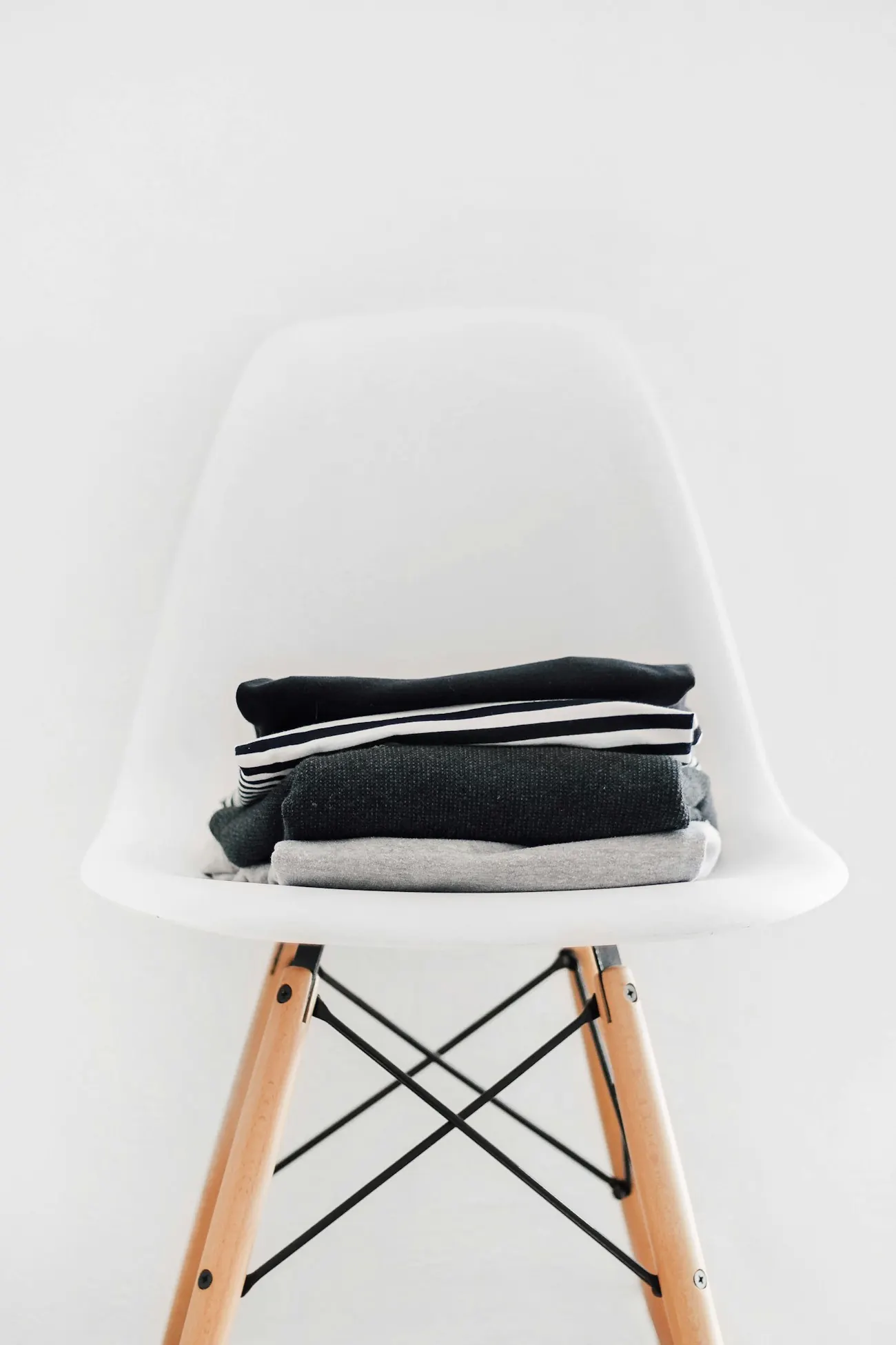 Stack of folded black, white and grey clothes on a chair