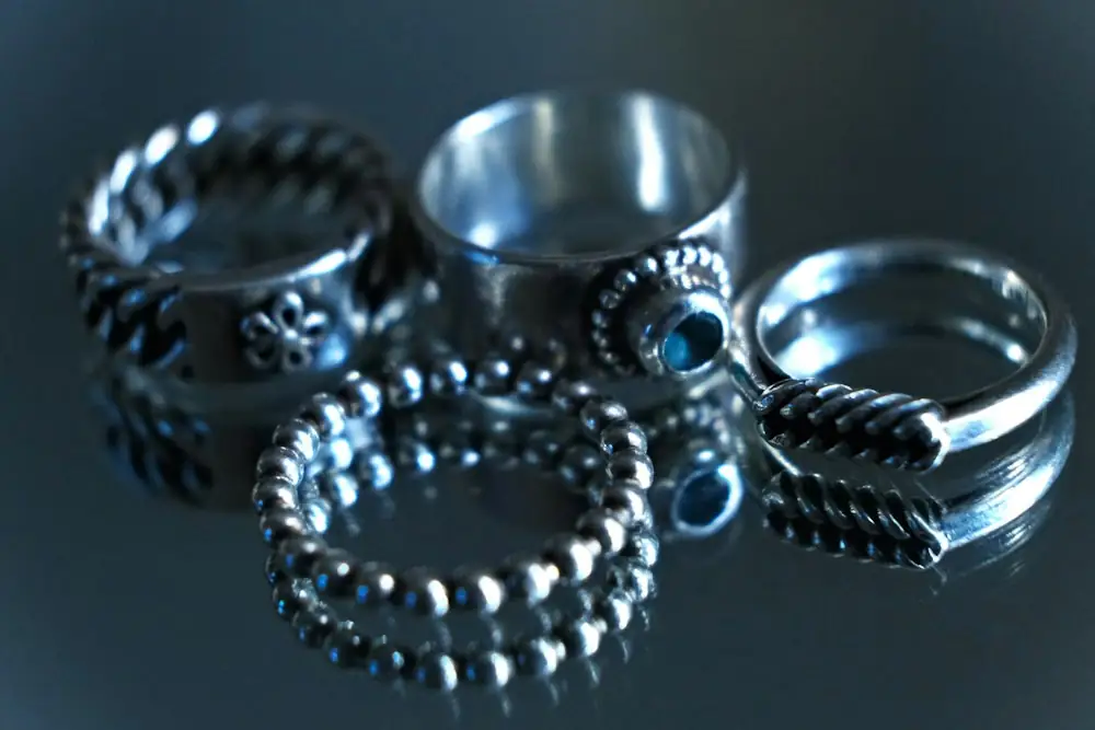 Oxidised sterling silver rings on a blue surface