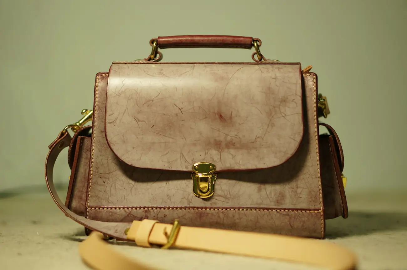 Structured tan leather handbag with a brass clasp