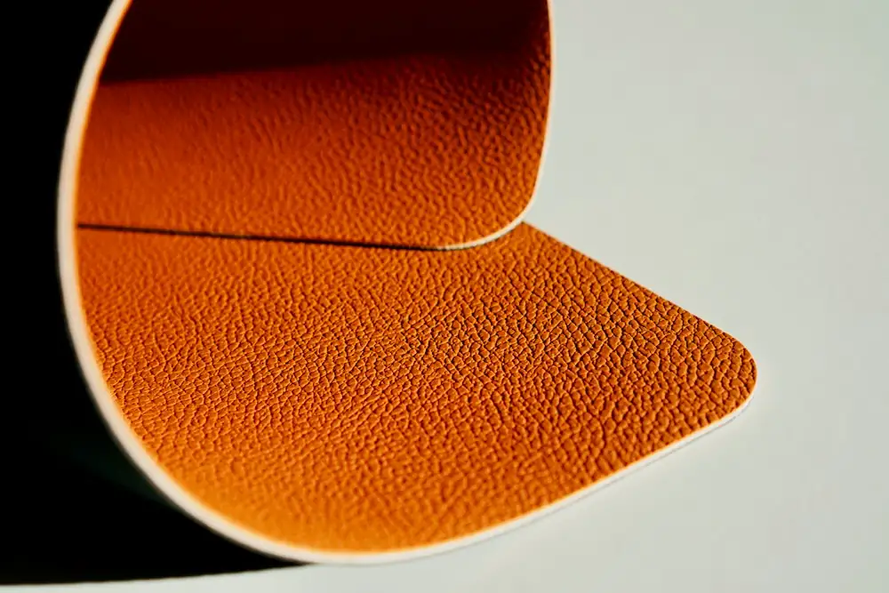 Curved sheet of orange pebbled leather