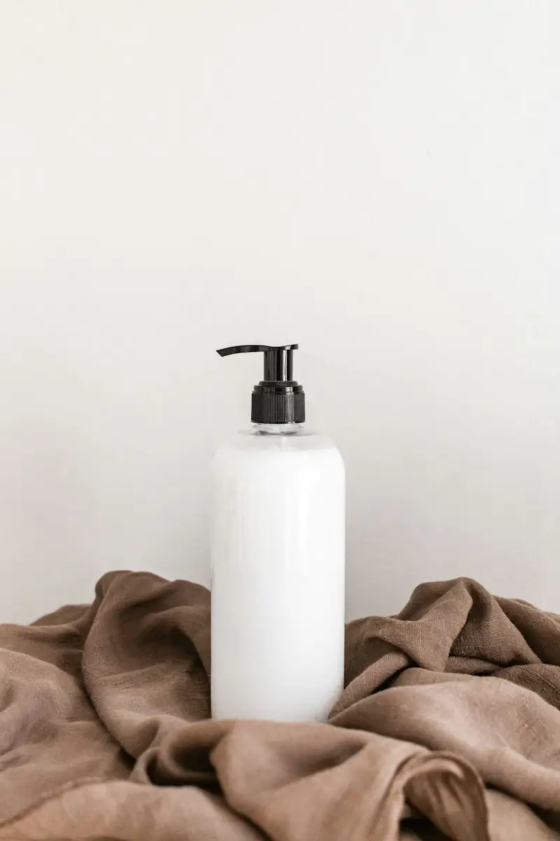 White pump bottle on a draped brown fabric