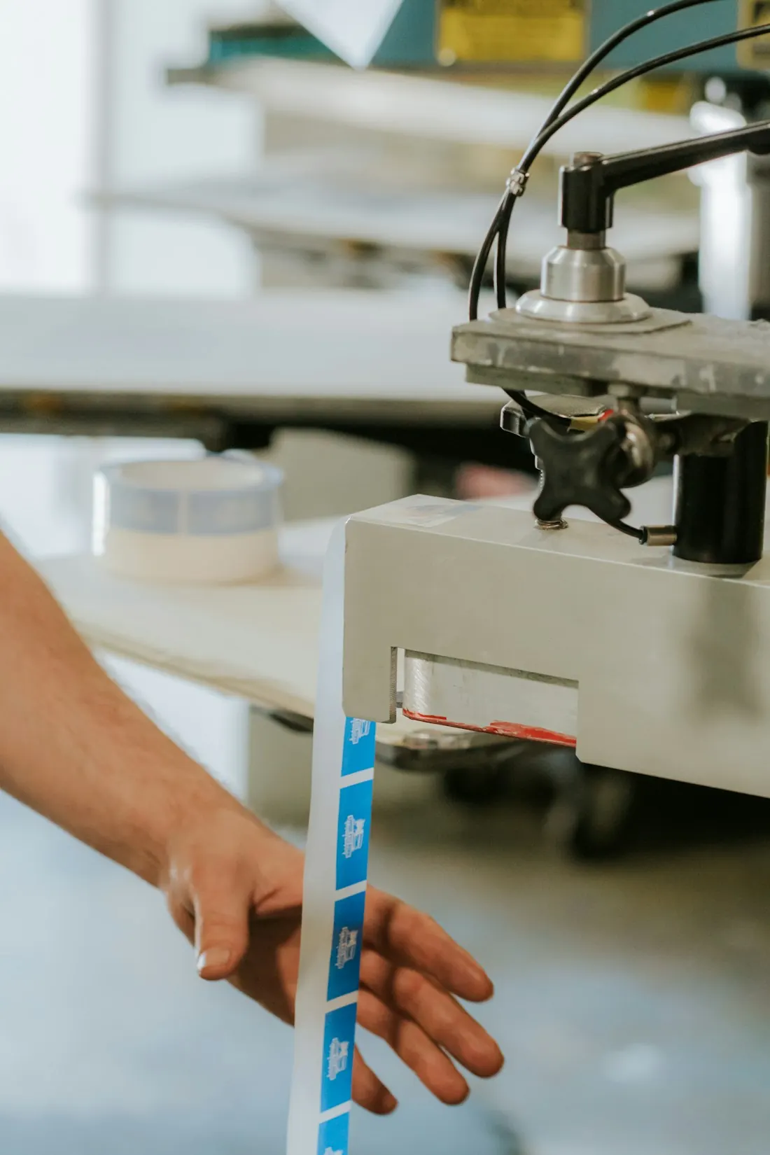 Woven label tape being fed into a label cutting machine
